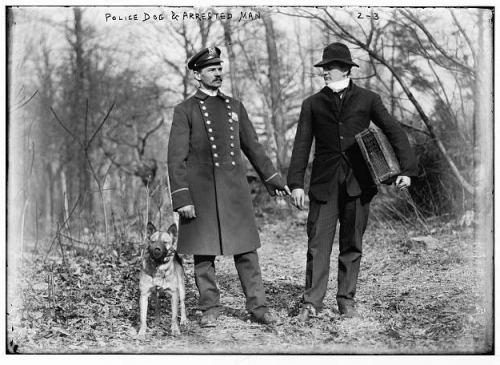An old photo of a man being arrested by a police officer, with a handwritten annotation on the picture.