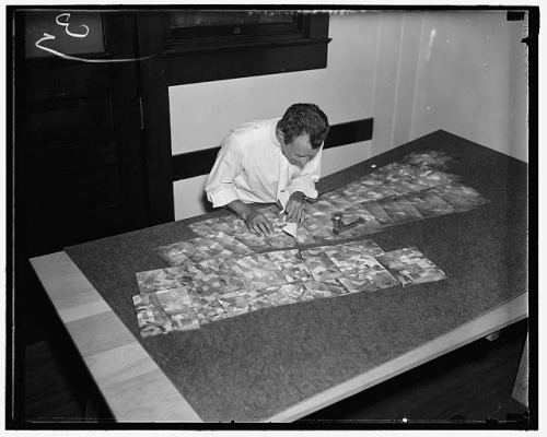 An AAA worker piecing together prints from the $3,000,000 map.