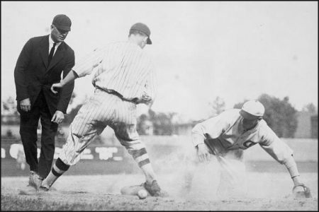 An umpire judging a play at second base, note the baseball on the ground behind the second baseman's right leg.